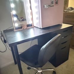 Black vanity with drawers and chair. 
