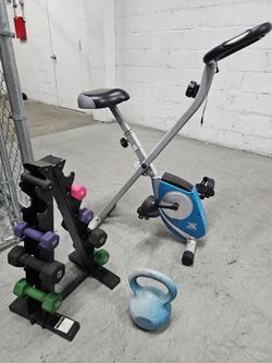 Folding Stationary Exercise Bike plus Fitness accessories.
Gray and blue folding stationary exercise bike with padded seat, handlebar grips, and peda