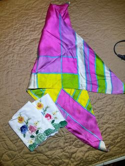 vibrant, geometric print silk scarf alongside embroidered white linens, likely classified as vintage clothing accessories and home decor
