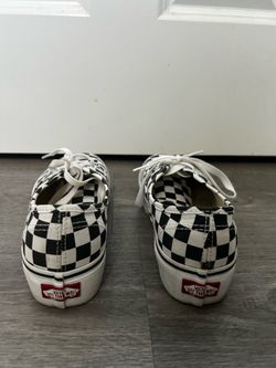 These Vans Authentic sneakers feature a classic black and white checkerboard pattern on the canvas upper.