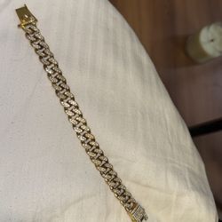 Iced out gold-tone bracelet fully set with moissanite stones.