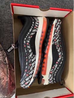 This is a pair of Nike Air Max 97 'Just Do It' sneakers in black with total orange accents.