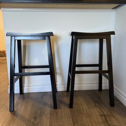 2 black solid wood stools