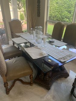 Antique style kitchen table with one piece glass top and lions carved into the base
