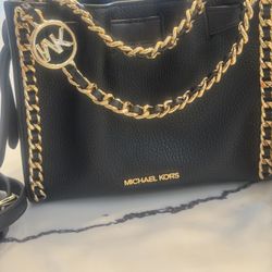 Michael Kors Leather Bag with Gold Chain  Beautiful leather bag by Michael Kors featuring an elegant gold-tone chain strap. The chain is detailed with
