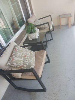 rocking chairs and table with cushions