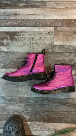 These are Dr. Martens 1460 Junior Reptile Emboss Boots in a vibrant metallic pink finish.