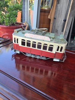 It is a vintage Lisbon tram model made of metal,