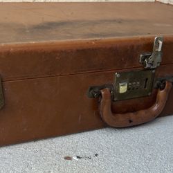 vintage leather briefcase or suitcase with a combination lock and the initials "W. B. K." on the front.