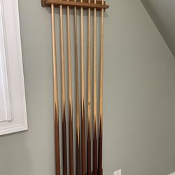Variety Of Different Pool Sticks And Mount