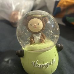 Adorable green and white snow globe featuring a bear in a bear suit 