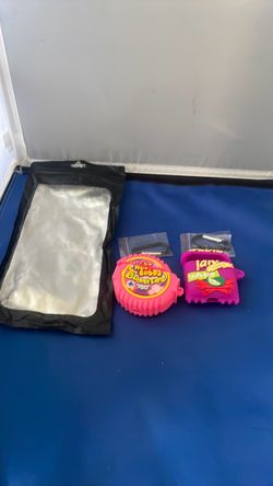 3D silicone AirPods cases shaped like a pink Hubba Bubba Bubble Tape roll and a purple bag of Takis Fuego chips.