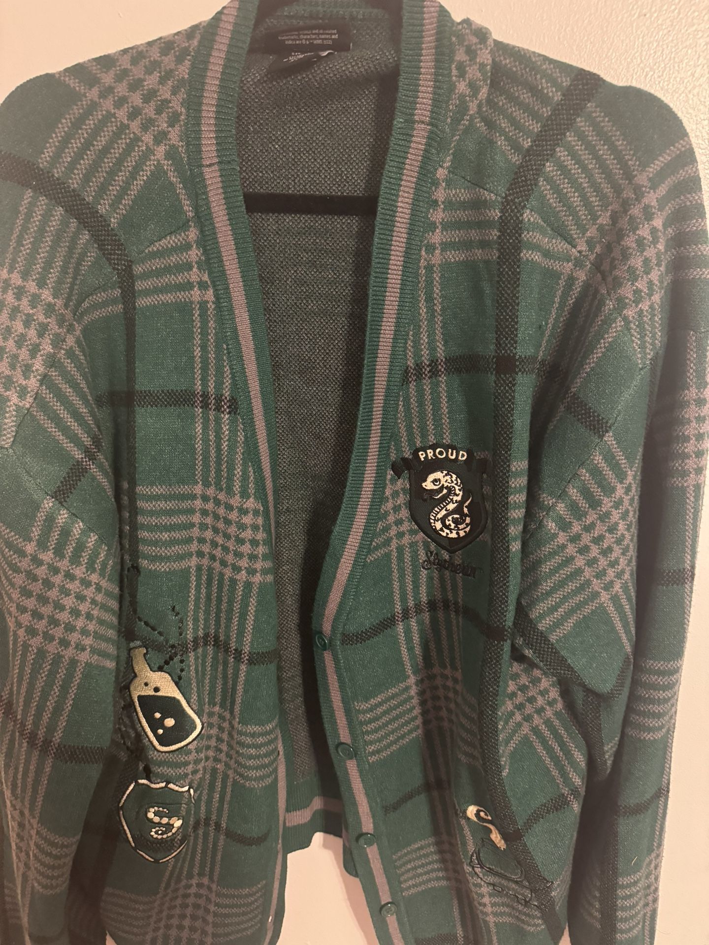 Green cardigan with Slytherin logo, featuring a preppy, glam, and boho style #HarryPotterInspired #SlytherinPride