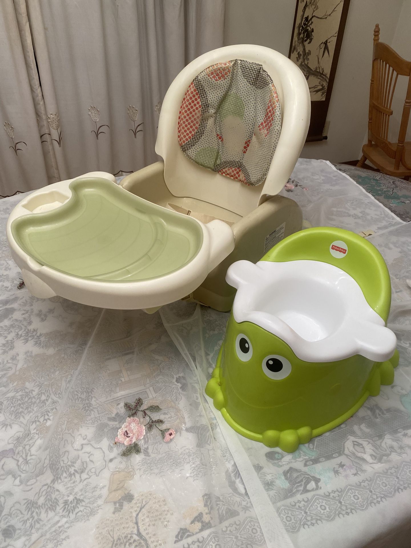 A Portable Baby Seat And A Fisher Price Groggy Potty