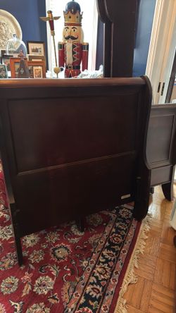 Twin dark wood sleigh bed.