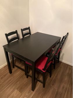 IKEA table with 4 chairs and cushions.
