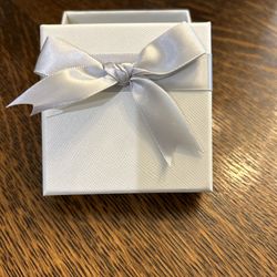 11 small white gift boxes with silver bow attached
