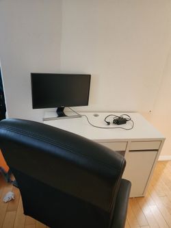 Working desk, monitor and black swivel chair