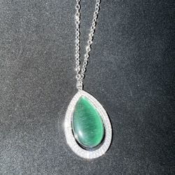 Paparazzi necklace featuring a large green stone pendant with rhinestones on a silver tone chain