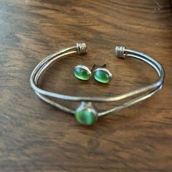 Vintage sterling, silver cuff bracelet, and earrings with green cat’s-eye stones