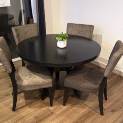 Black Round Pedestal Dining Table with 4 Gray Upholstered Chairs