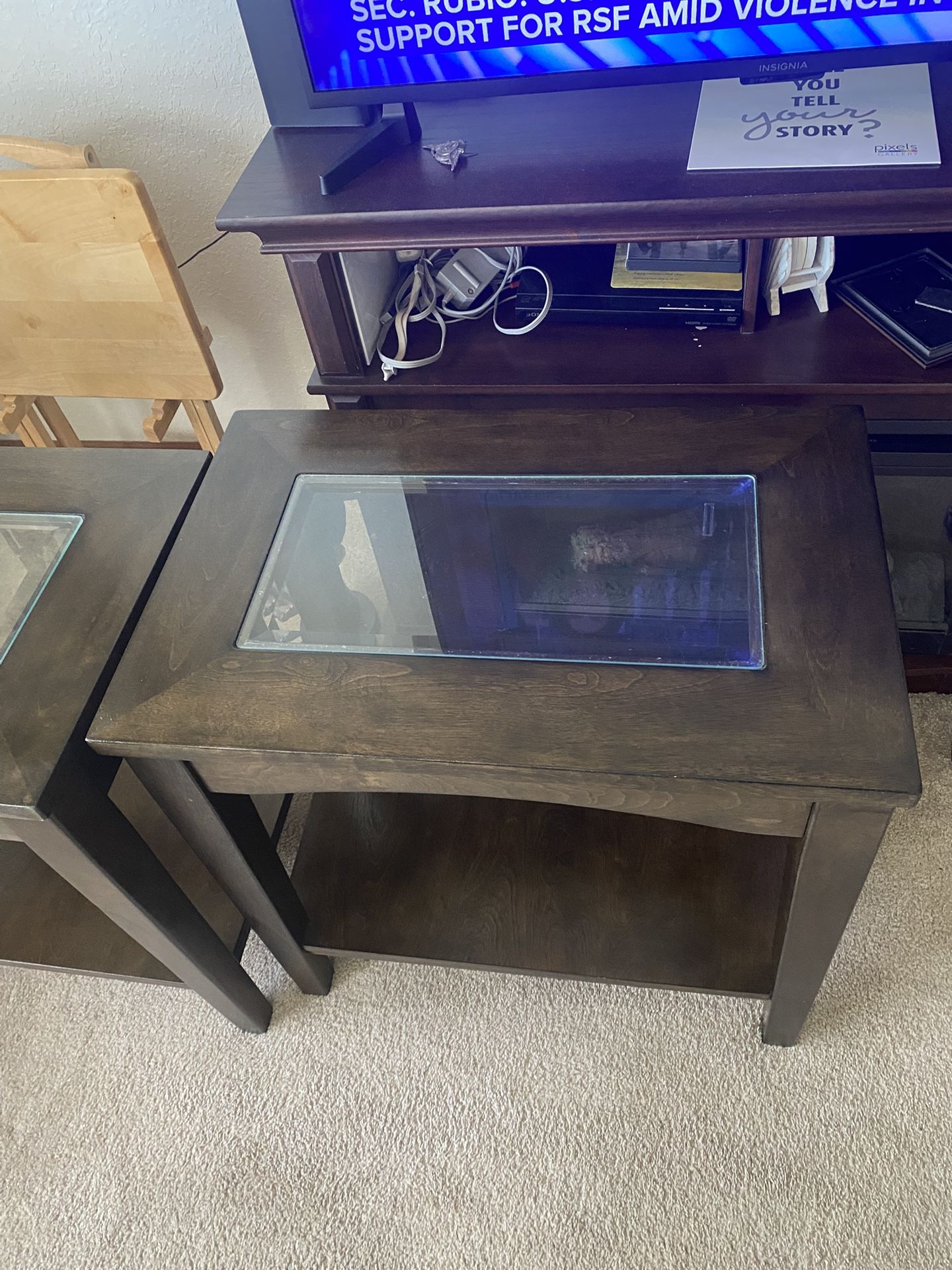 Two dark wood end table with a glass insert and a bottom shelf