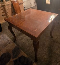 Solid wood 
Polished wood dining table has a warm brown finish and features a draw-leaf extension design. The table is supported by four cabriole legs