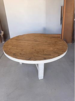 Round farmhouse table, natural wood top with a whitewashed distressed base and apron, seats 6.