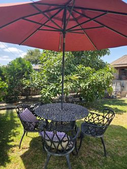 Antique wrough iron table and chairs with umbrella and stand
