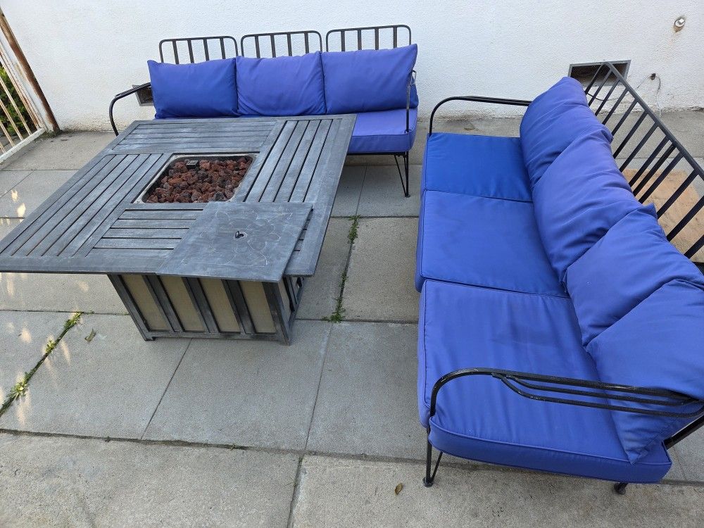 Set of two sofas with a gas fire table and cushions.