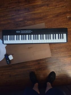 Portable 61-key foldable electronic piano keyboard with a black chassis and a digital control panel on the right side.