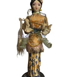 vintage Japanese Geisha doll. These dolls are known for their intricate details and are often depicted wearing elegant kimonos.  Geisha dolls originat