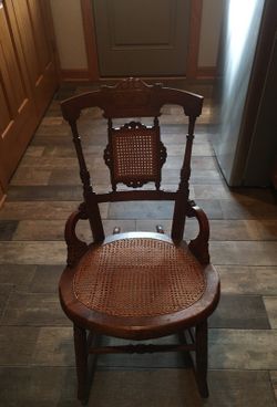 Small vintage wooden rocker with wicker seat.