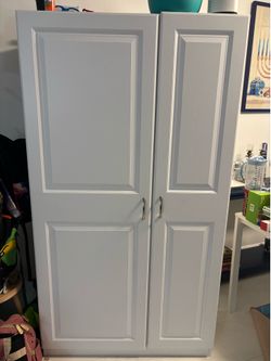 Tall storage cabinet with shelves and rod