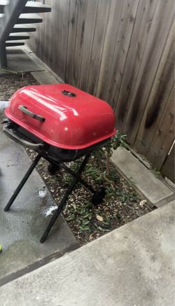 In clean condition, large red barbecue/grill with wheels.