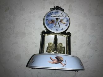 vintage Waltham porcelain anniversary clock featuring a glass dome and cherub motifs