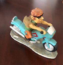 Vintage comical resin figurine featuring a stylized biker riding a teal motorcycle, Size 8 inches x 5-1/2 inches $15