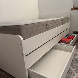 Two layered white bed twin sized. One white table with shelf’s.