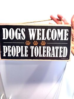 Dogs Welcome people tolerated wall hanging.