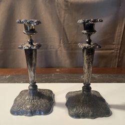 Vintage set of 2 silverplate pillar candle holders stands at 10 inches tall, adding a touch of elegance to any space.