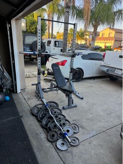 Bench press/squat rack with 7ft 45lb bar and 290lbs of Olympic weights plus curl bar