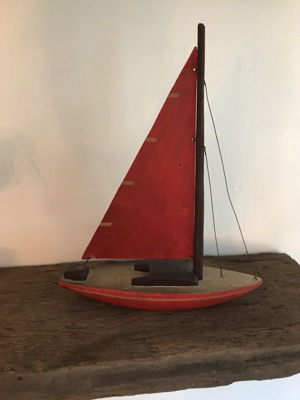 Hand carved red wooden sailboat