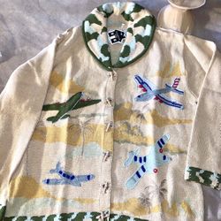 Vintage cardigan  by the brand Storybook Knits and features a whimsical airplane and tropical scene design. - size Medium