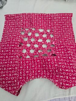 toddler in a traditional red printed mesh and cloth four-claw baby carrier