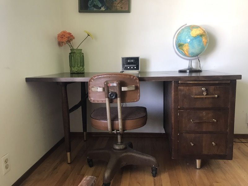 Mid century modern wood desk, tanker chair and lighted globe.