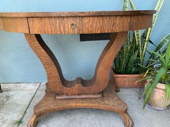Antique tiger oak oval pedestal table with a drawer.