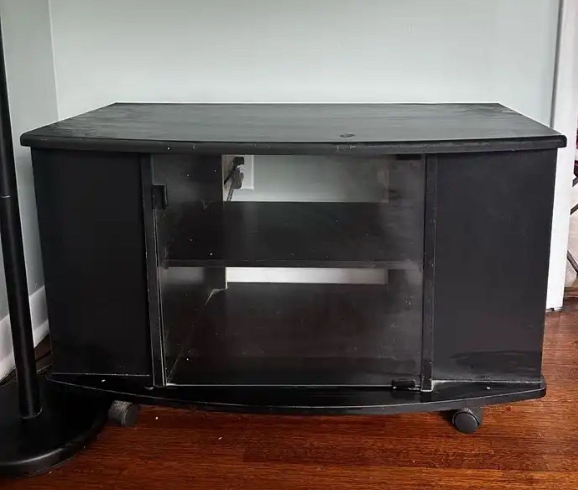 Black TV stand with glass doors and shelves.