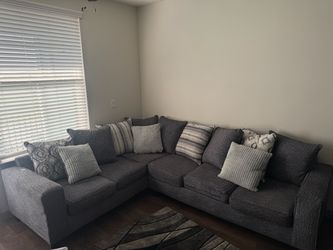 L sectional couch with rug and glass coffee table
