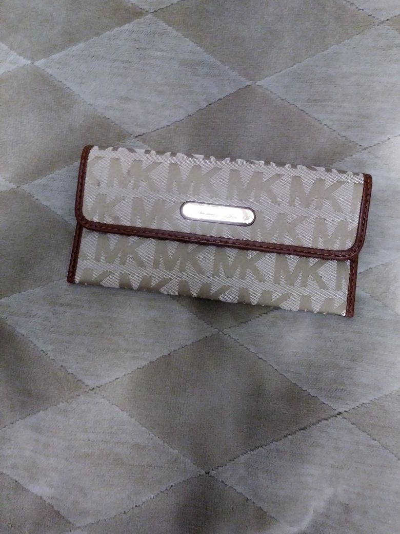 Authentic Michael Kors wallet made of material with a cognac color leather trim. Clean on the nside and out, no stains, snags, rips or discolorations.