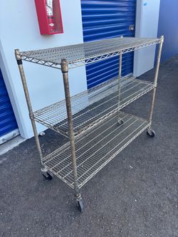 Heavy-duty 3-tier wire shelving unit on caster wheels.
